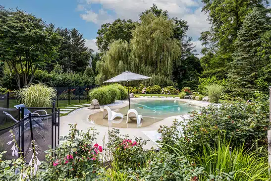 A Biodesign pool in a lush, landscaped backyard
